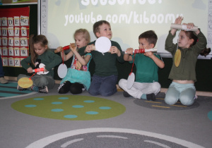 Dzieci przyciągają na wstążce monetę.