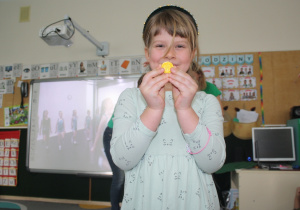 Dziewczynka pokazuje zdobytą czekoladową monetę.
