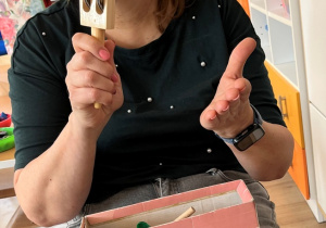 Nauczycielka wystukuje rytm na tamburynie.