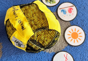 Na dywanie wokól pileczki obrazki atrybutów wiosny.