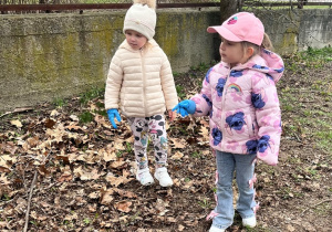 Dziewczynki poszukują śmieci.