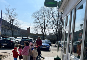 Dzieci przed sklepem spożywczym.