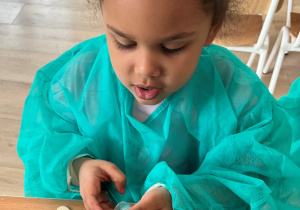 Dziewczynka szykuje zastrzyk dla pacjenta.