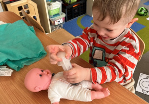 Chłopiec robi zastrzyk lalce.