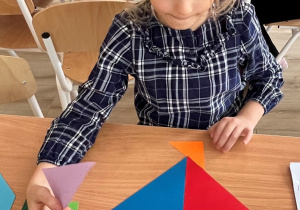 Dziewczynka układa ptaka według wzoru.