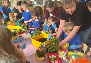 Dzieci i rodzice wykonuja stroiki wielkanocne.