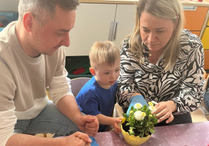 Rodzice z chłopcem wykonuja stroik.