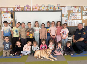 Dzieci pozują do wspólnego zdjęcia z pieskiem.