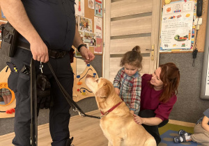 Dziecko głaszcze pieska.