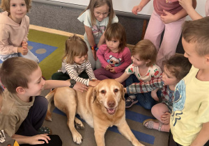 Dzieci głaszczą pieska.