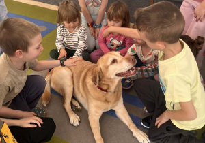 Dzieci głaszczą pieska.