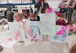Dzieci pokazują rysunki.
