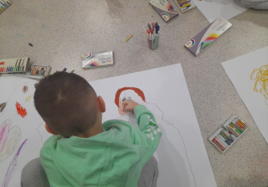 Chłopiec rysuje siebie na papierze.