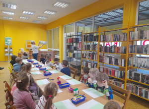 Dzieci słuchają bajki siedząc w bibliotece
