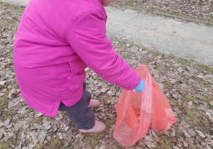 Dziewczynka wrzuca śmieci.