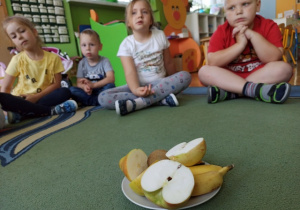 dzieci oglądają jak wyglądają owoce po przekrojeniu