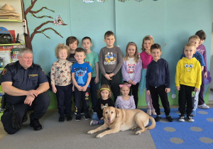 Dzieci pozują do zdjęcia z pieskiem.