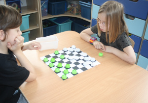 Dzieci rozgrywają mecz warcabowy.