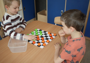 Dzieci rozgrywają mecz warcabowy.