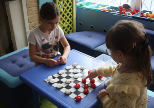 Dzieci rozgrywają mecz warcabowy.