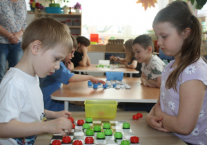 Dzieci rozgrywają mecz warcabowy.