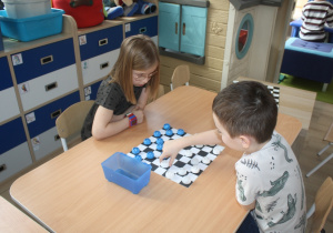 Dzieci rozgrywają mecz warcabowy.