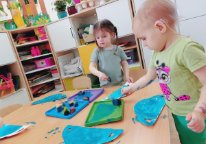 Dzieci wykonują prace plastyczne.