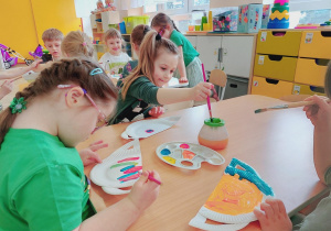 Dzieci malują farbami.