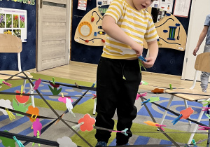 Chłopiec przypina spinacz do koszulki.