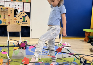 Dziewczynka pokonuje nitki pajęczyny.