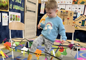 Chłopiec przechodzi po pajęczynie.