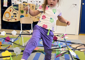 Dziewczynka przechodzi i zbiera kwiatek.