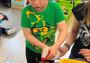 Dziewczynka pryska wodą zasadzone fasolki.