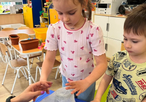 Dziewczynka zakłada gazę na słoik.