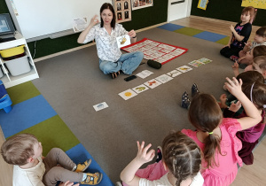 Dzieci pokazują znaki migowe.