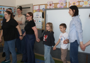 Rodzice tańczą wspólnie z dziećmi.