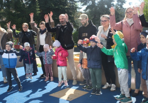Dzieci i rodzice tworzą krajobraz na folii.