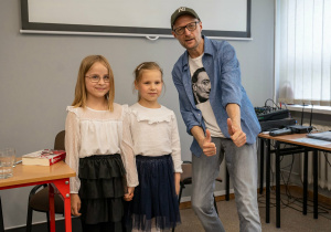 Autor wraz z dziećmi pozuje do zdjęcia.
