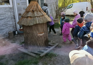 Dzieci wchodzą do pracowni pszczelarskiej.