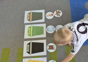 Dzieci uczą się jak segregować śmieci.