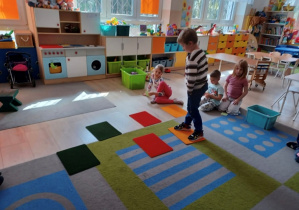 Chłopiec skacze po kolorowych planszach.