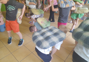 Dzieci naśladują żółwie podczas zabawy ruchowej.