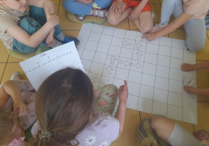 Dzieci układają strzałki na planszy.