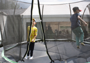 Dzieci skaczą na trampolinie.