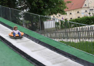 Dzieci zjeżdżają na pontonach.