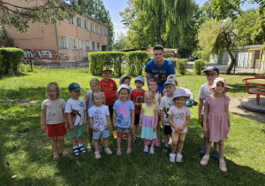 Dzieci pozują z trenerem do zdjęcia.