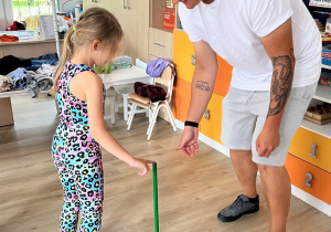 Dziewczynka z tatą - zabawa z kijkiem.