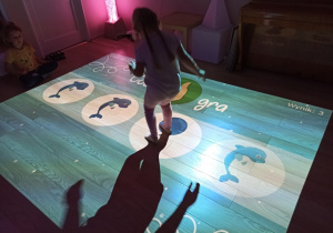 dziewczynka bawi się na podłodze interaktywnej