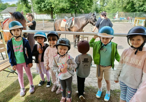 Dzieci stoją przy wybiegu dla konia.