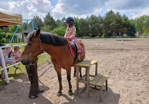 Dziecko siedzi na koniu.